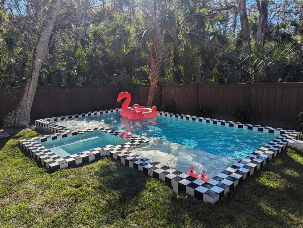 Pool and spa with black-and-white 6x6 checkerboard waterline tile and coping