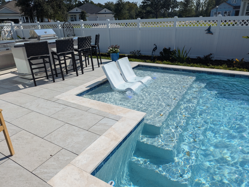 Traditional blue 6x6 tile band paired with ivory travertine coping and shallow sun shelf