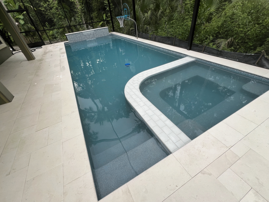 Mosaic application visible on the raised beam wall near the water feature and the waterline tile